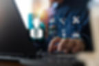 Businessperson typing on a laptop with glowing 24/7 support, tools, and analytics icons in a dark office.