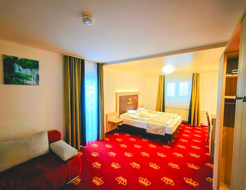 Schlafzimmer der Ferienwohnung mit rotem Teppich und Doppelbett