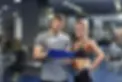 Trainer und Frau mit Notizen im Fitnessstudio, Lavital Fitness. Beratung und Training.