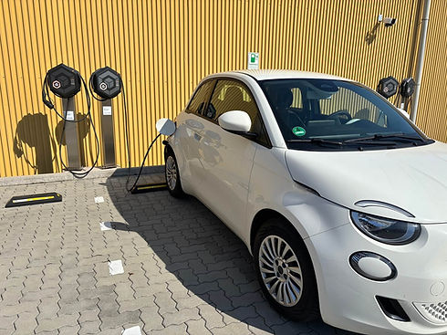 Weißes Elektroauto lädt an Ladestationen