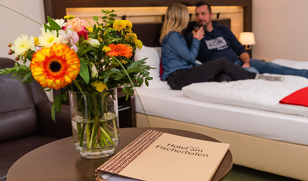 Gästemappe vom Hotel am Fischerhafen und Blumenstrauß.