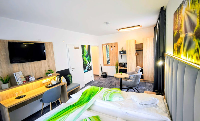 Modernes Doppelzimmer mit Schreibtisch und Sitzecke