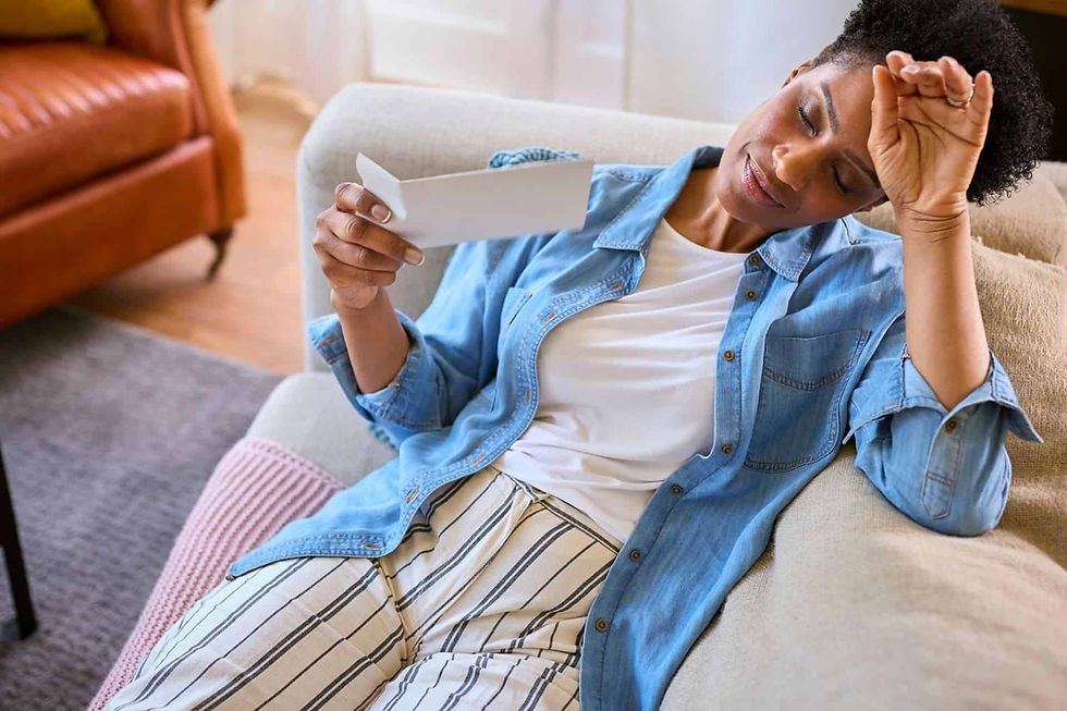 a woman with perimenopause lying on the couch, touching her forehead.