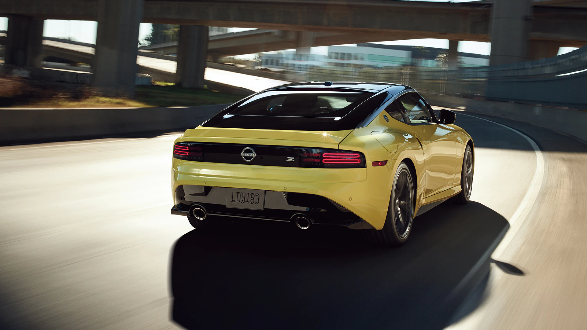 2023-nissan-z-in-yellow-driving-on-a-highway-with-two-tone-exterior-l.jpg.webp