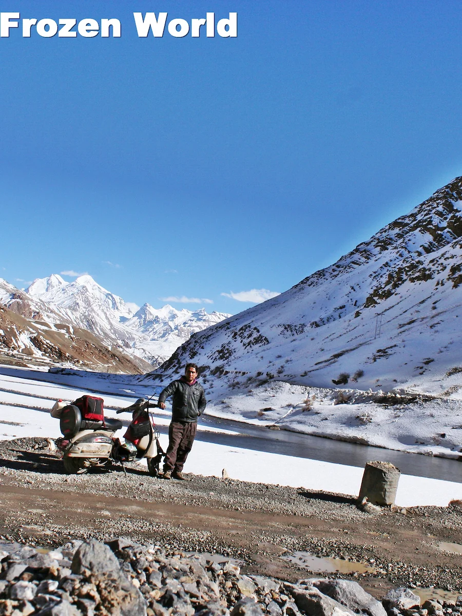 a man with scooter on frozen himalyas standing on road