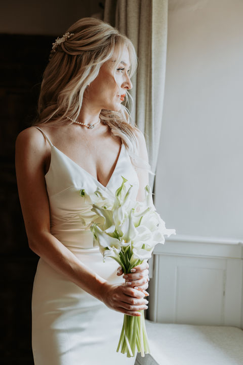 Bride looking out of a window