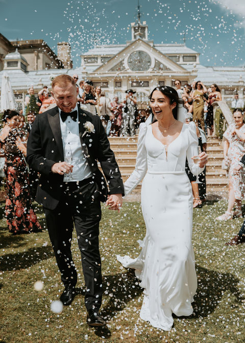 Bride and groom walking in confetti