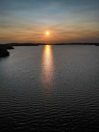 Golden Sunset reflecting on beautiful calm lake water.