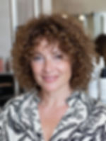 Curly bob with curly bangs for women over 50 creating texture and youthful volume.