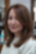 Long layered hairstyle with a deep side part for round faces over 40.
