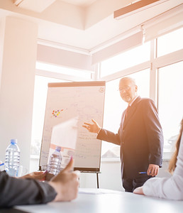 two-businesswoman-looking-businessman-giving-presentation.jpg