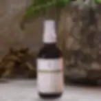 Thumbnail: 4 oz amber glass bottle of Facial Toner on a stone surface, surrounded by a soft spa atmosphere with blurred background