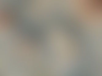 Splotches of orange and beige water form in craters of a large flat gray rock.