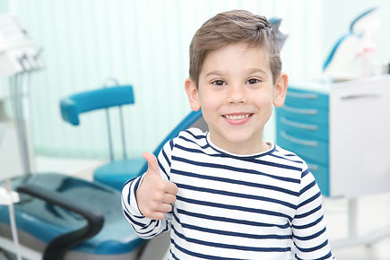 Cute little boy showing thumb up sign at dentist's office.jpg