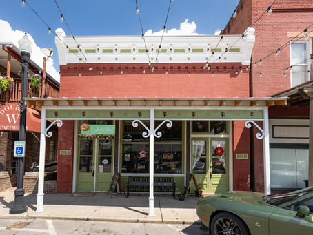 Historic storefronts line downtown Wartrace at sunset, with the Tennessee Walking Horse National Museum and the iconic Welcome to Wartrace gateway in view.