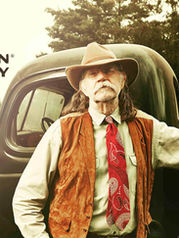 Col. Littleton, The Great American Leather Company. Col. Littleton leaning on antique car.