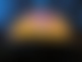 A geodesic dome cabin glows warmly from within at dusk, its interior lights illuminating the structure against the darker forest backdrop.