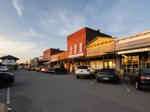 Historic storefronts line downtown Wartrace at sunset, with the Tennessee Walking Horse National Museum and the iconic Welcome to Wartrace gateway in view.