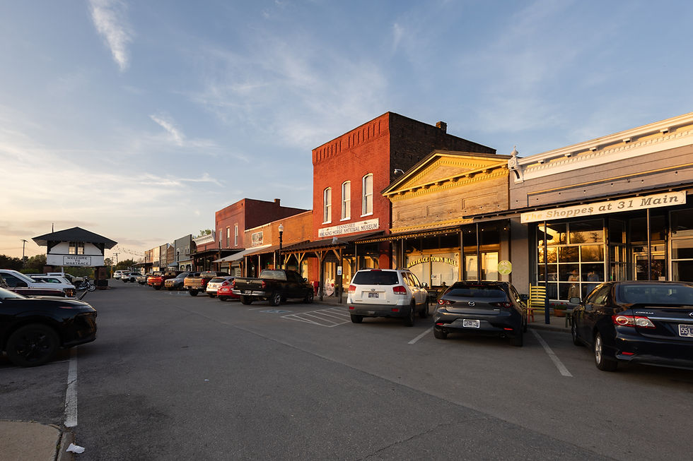 Historic storefronts line downtown Wartrace at sunset, with the Tennessee Walking Horse National Museum and the iconic Welcome to Wartrace gateway in view.