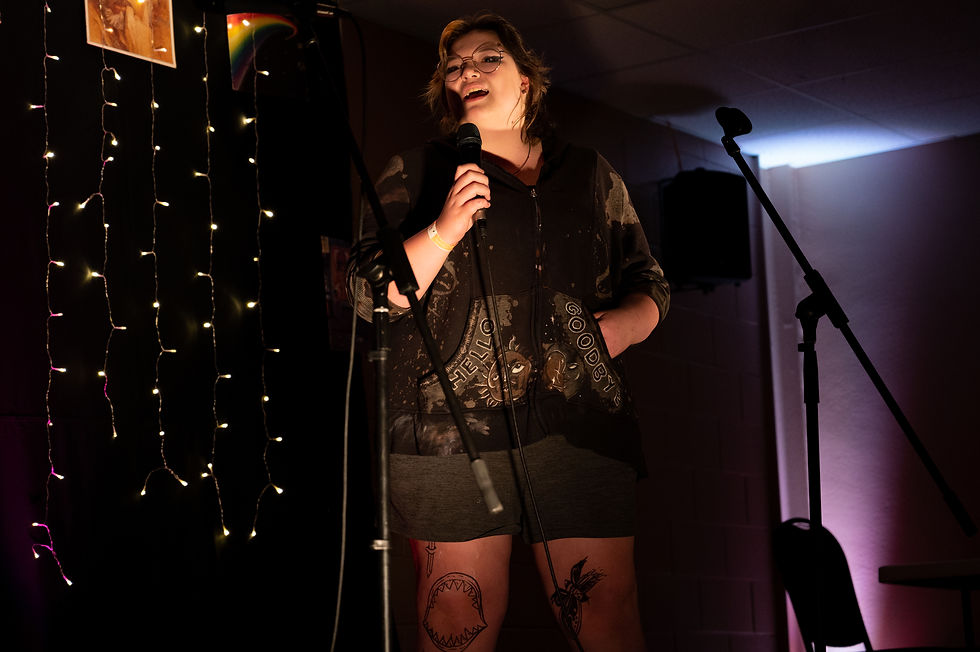 Student singing with a mic in front of the Karaoke Lounge