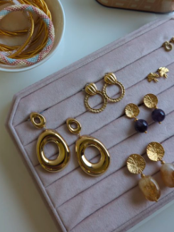 Boite à bijoux avec des boucles d'oreilles dorées fantaisie. 