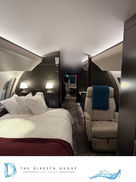 Private jet cabin with dark wood trim and leather seating