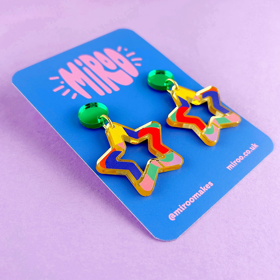 Thumbnail: A pair of colourful star shaped earrings. Dangle earrings made from mirrored gold acrylic with colourful pattern