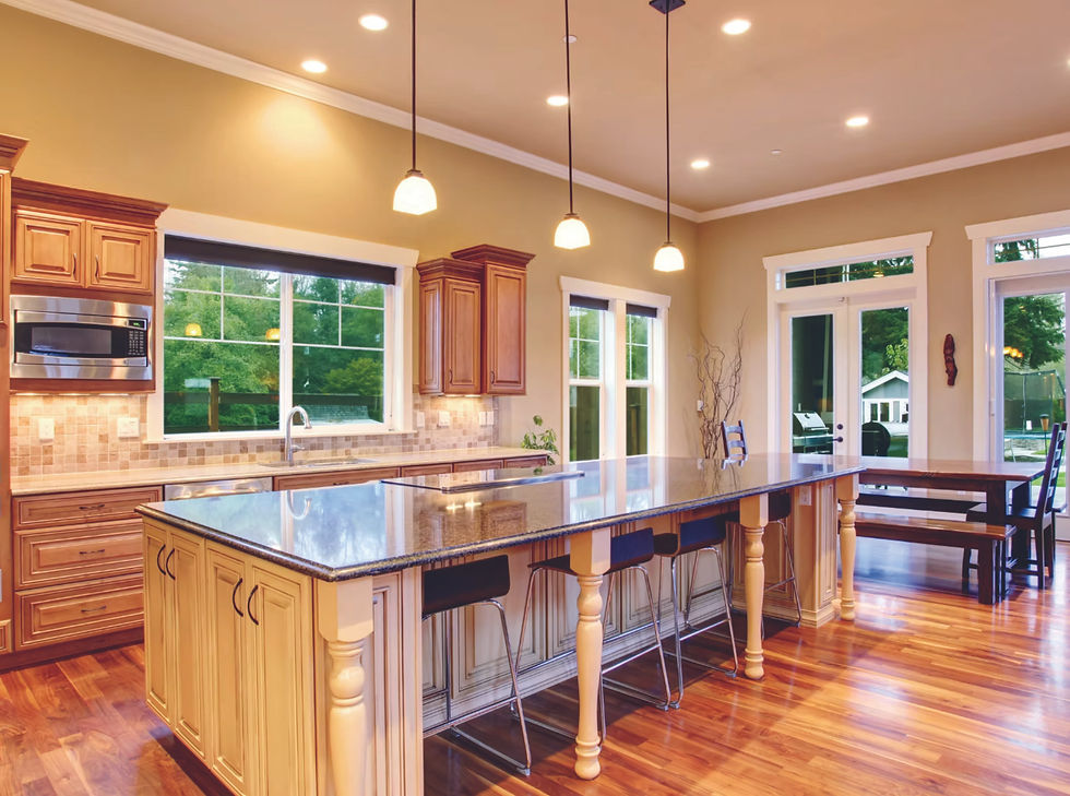 Illustrative kitchen with wood cabinets, a large island, pendant lights and wood flooring