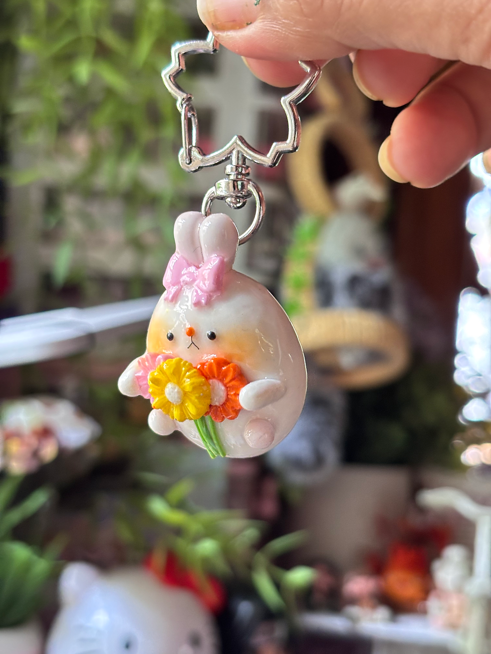 Thumbnail: bunny keychain handmade clay bunny holding flower bouquet cute round design - Tilted View