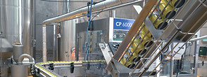Can clip applicator attaching multipack handles to beverage cans on production line