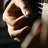 Nahansicht eines Gitarrenspielers. Nur Hand und Akustikgitarren Body