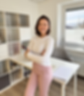 Frau Psychologin vor dem Tisch lachend, in einem Büro, Regale im Hintergrund.
