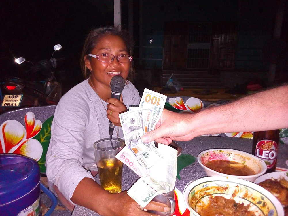 A Thai woman singing karaoke for tips