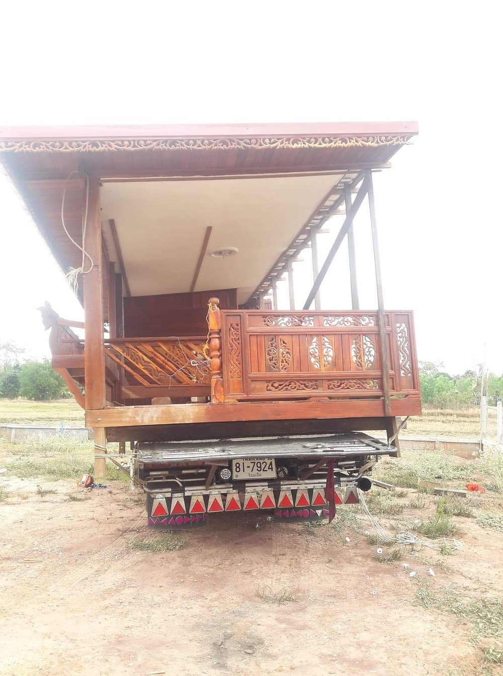 Traditional wooden thai house arriving on site on the back of a truck