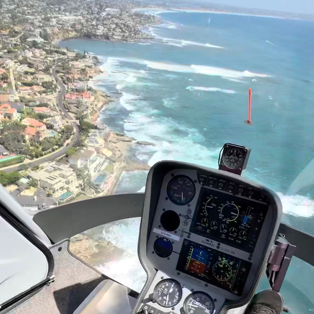 Mission Helicopters flying over the coastline of San Diego