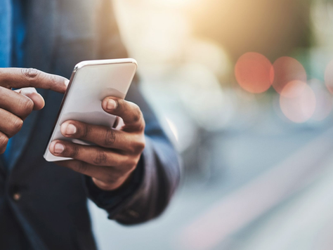 Person using a smartphone on a city street. Man using a mobile phone. Source: Zoom Blog: "Zoom Phone Mobile is here: AI-first business calling for your native mobile dialer" April 28, 2026