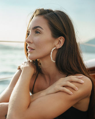Woman with pearl earrings looks out at water in EDITORIAL PORTRAIT, Jenia Ria