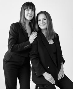Two women in black suits pose for a professional portrait, Jenia Ria personal branding photography