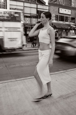 Lifestyle photoshoot for a local apparel brand, woman wearing a white knit set and walking on the streets of Vancouver