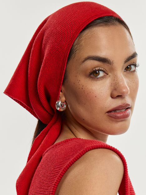 Woman wearing red scarf and earrings, looking at the camera. E-COMMERCE/FASHION