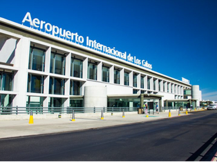 Un automóvil de Uber esperando afuera de la terminal del Aeropuerto Internacional de Los Cabos, con turistas.