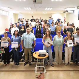 UABCS Marine Biology students detailing their scientific research projects with charts and maps to professors during a university symposium in La Paz.