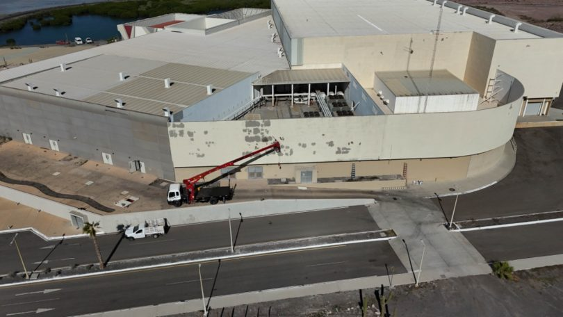 Trabajadores realizando labores de pintura y remodelación en la fachada de un edificio gubernamental en Baja California Sur como parte del programa de rehabilitación 2026.