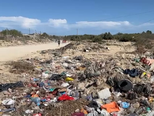 Personal de Ecología inspeccionando un cauce de arroyo limpio en Los Cabos, con letreros de prohibición de tirar basura y el paisaje desértico de fondo.