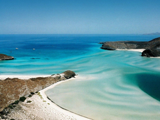 Vista aérea de una playa virgen en Baja California Sur con aguas turquesas y desierto intacto, ejemplificando la conservación ambiental resaltada por Farid Dieck.