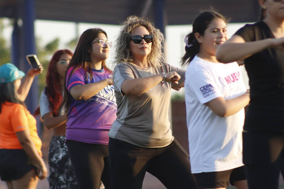 Un grupo de personas de distintas edades realizando ejercicios de resistencia con cuerdas y pesas rusas al aire libre en las canchas del Centro Deportivo El Piojillo en La Paz.