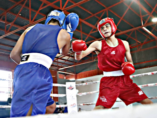 Two young boxers exchanging blows in the ring during the municipal selective in La Paz at the Manuel Gómez Jiménez court.