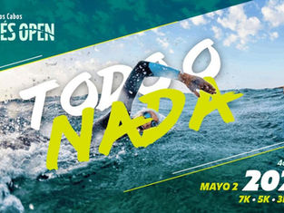 Open water swimmers equipped with bright colored caps and goggles standing at the shore of Playa Palmilla ready for the start of Cortés Open 2026.