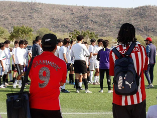 Cientos de jóvenes futbolistas en La Paz, BCS, escuchando las indicaciones de los visores oficiales del Club Guadalajara antes de iniciar las pruebas de selección profesional de marzo 2026.