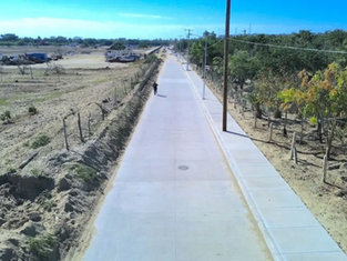 Trabajadores y maquinaria pesada realizando el colado de concreto hidráulico en el Camino Viejo de Cabo San Lucas, febrero de 2026.